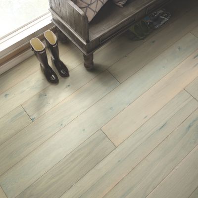 hardwood flooring in a entryway with bench and boots